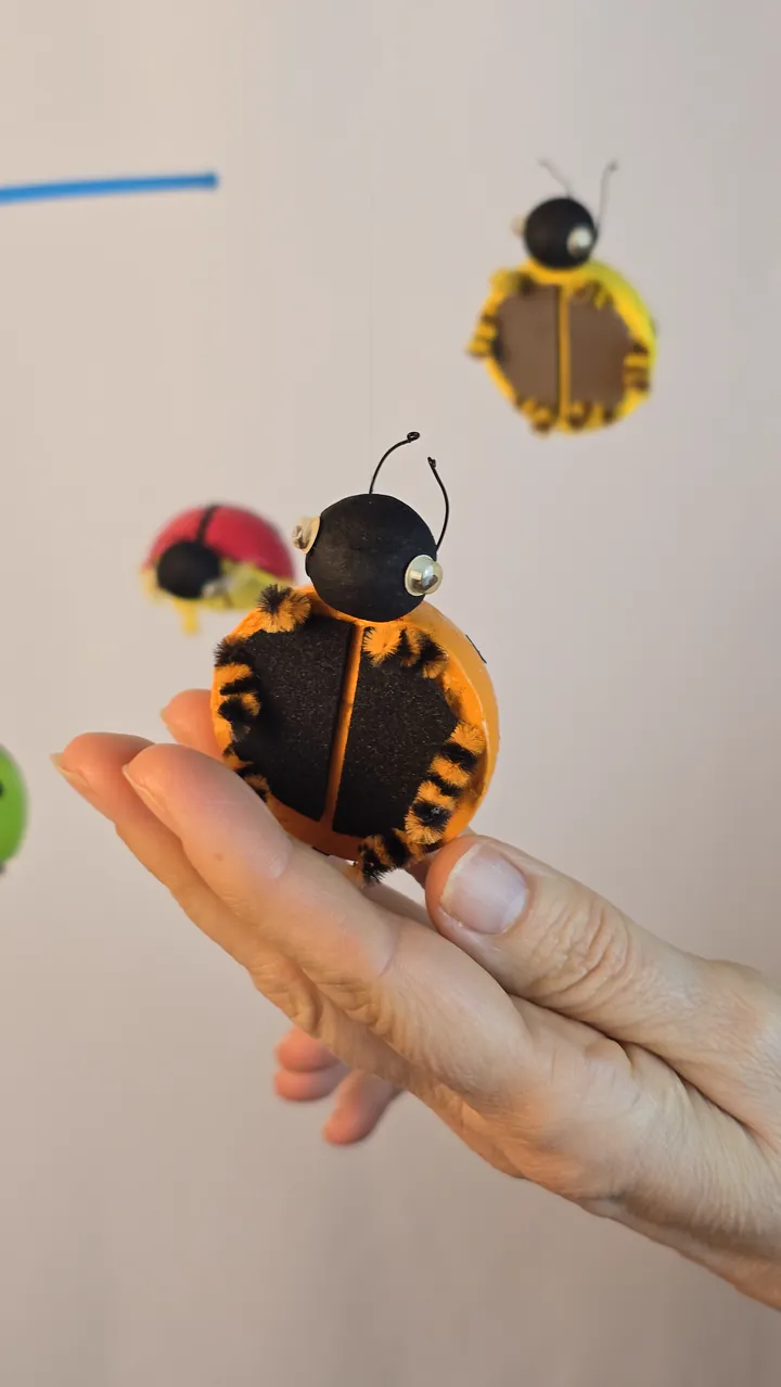 Mobile coccinelles - main de Clotilde tenant une coccinelle