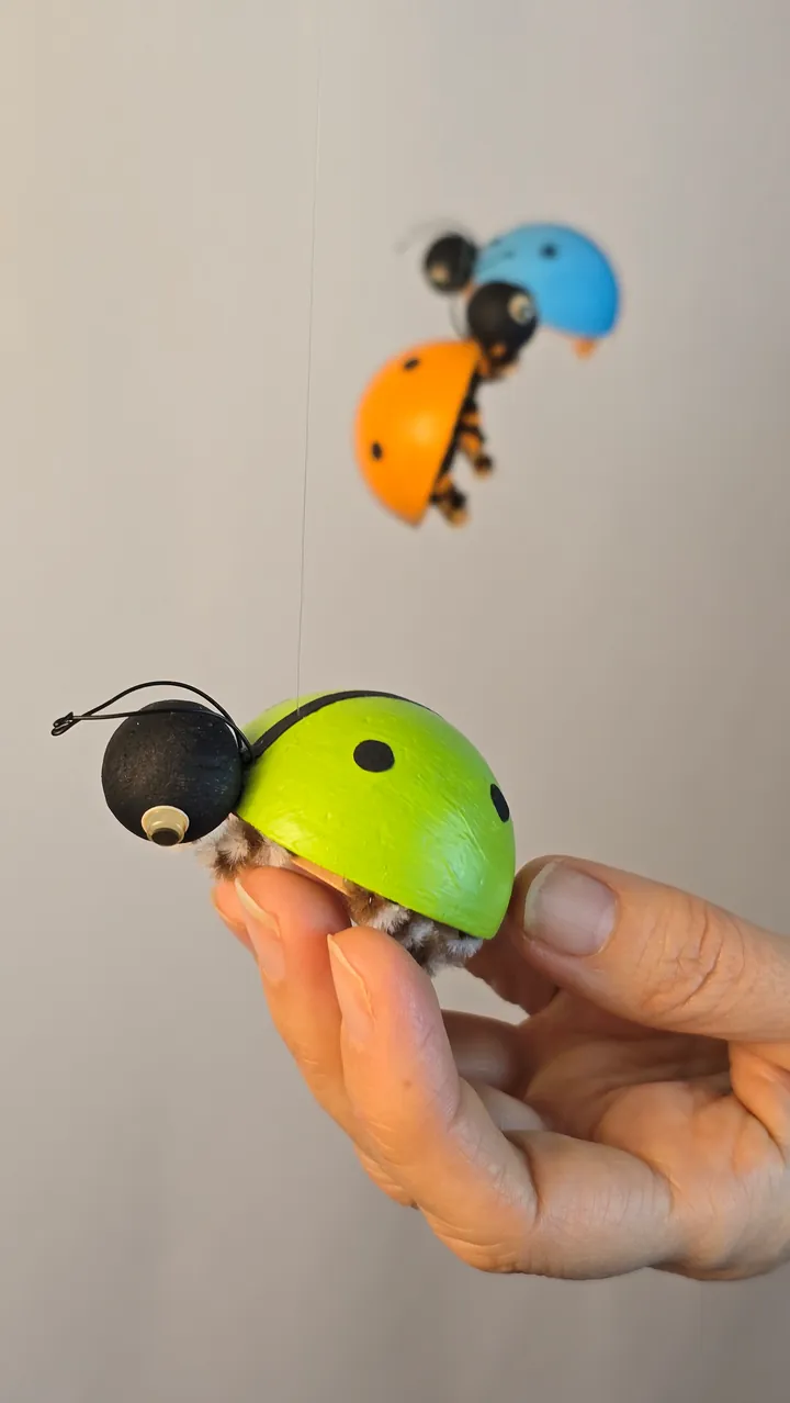 Mobile coccinelles - main de Clotilde, vue rapprochée du dos bombé