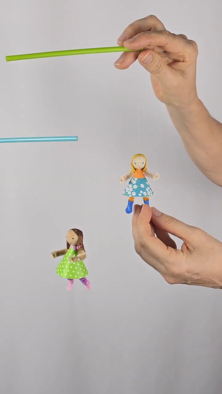 Mobile de petites coquettes - mains de Clotilde présentant le mobile