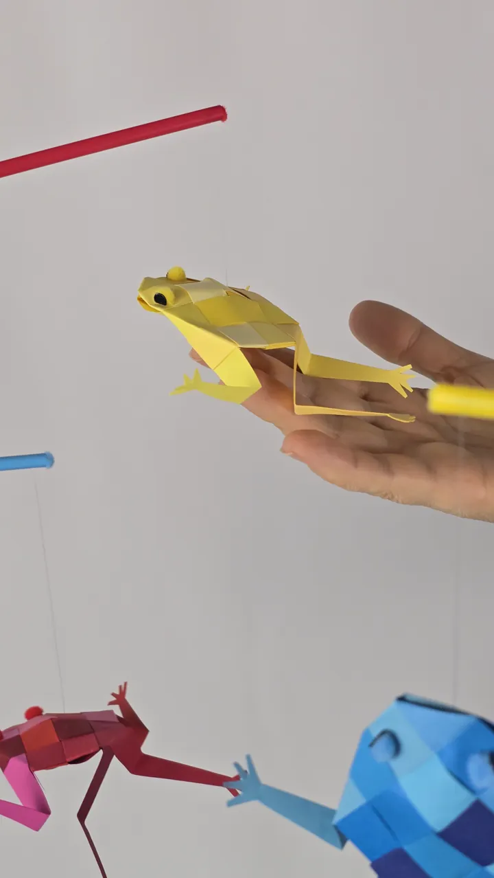 Mobile Rainettes en Fête - détail tenu en main, pattes prêtes à bondir