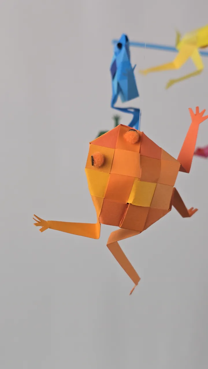 Mobile Rainettes en Fête - détail d'une rainette et de son tissage de papiers colorés