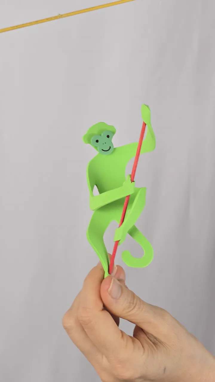 Mobile de singes colorés - mains de Clotilde présentant le mobile