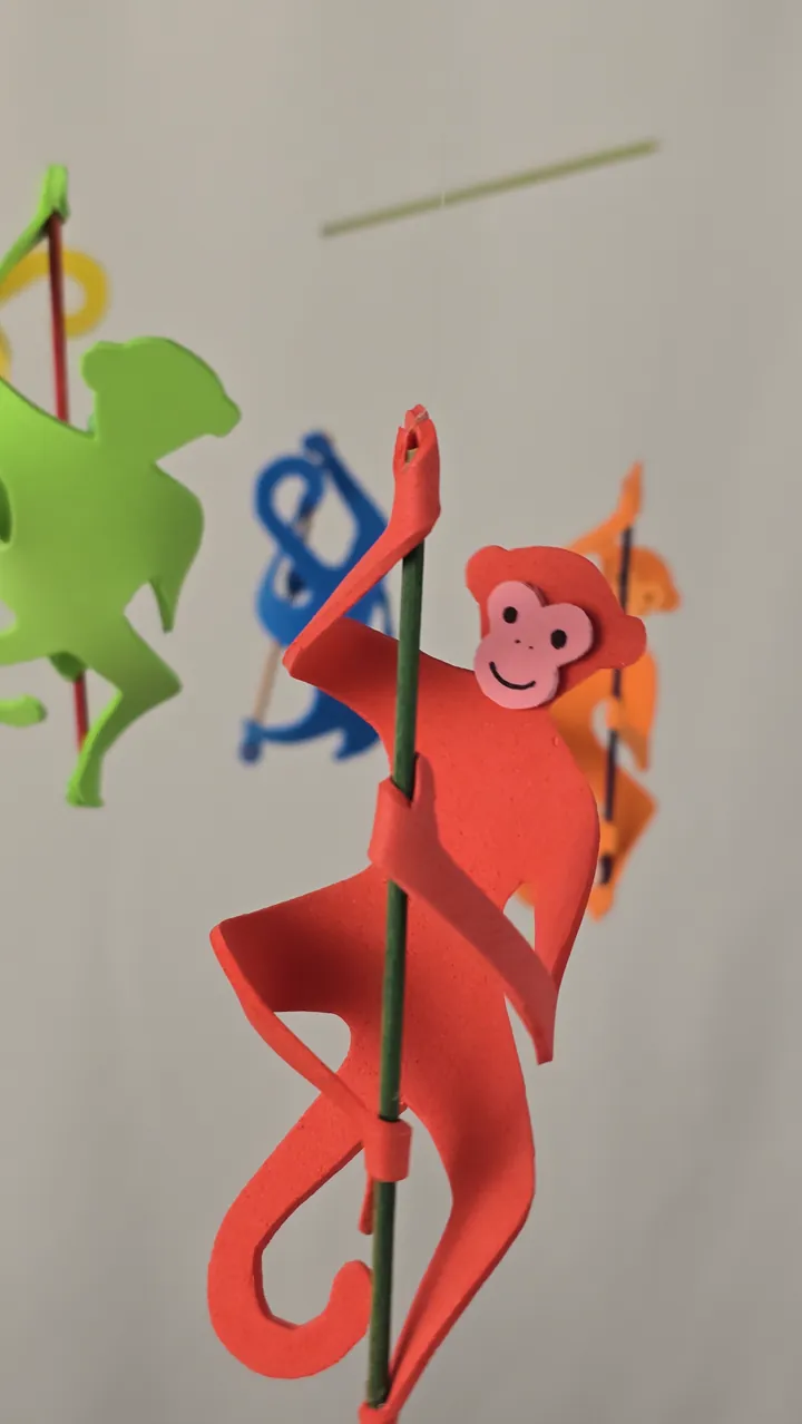 Mobile de singes colorés - détail des longs membres et couleurs vives