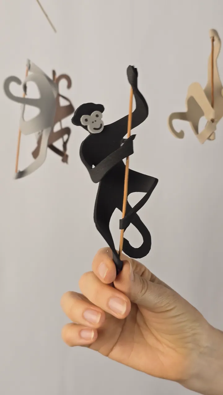 Mobile de singes naturels - main de Clotilde tenant un singe acrobate