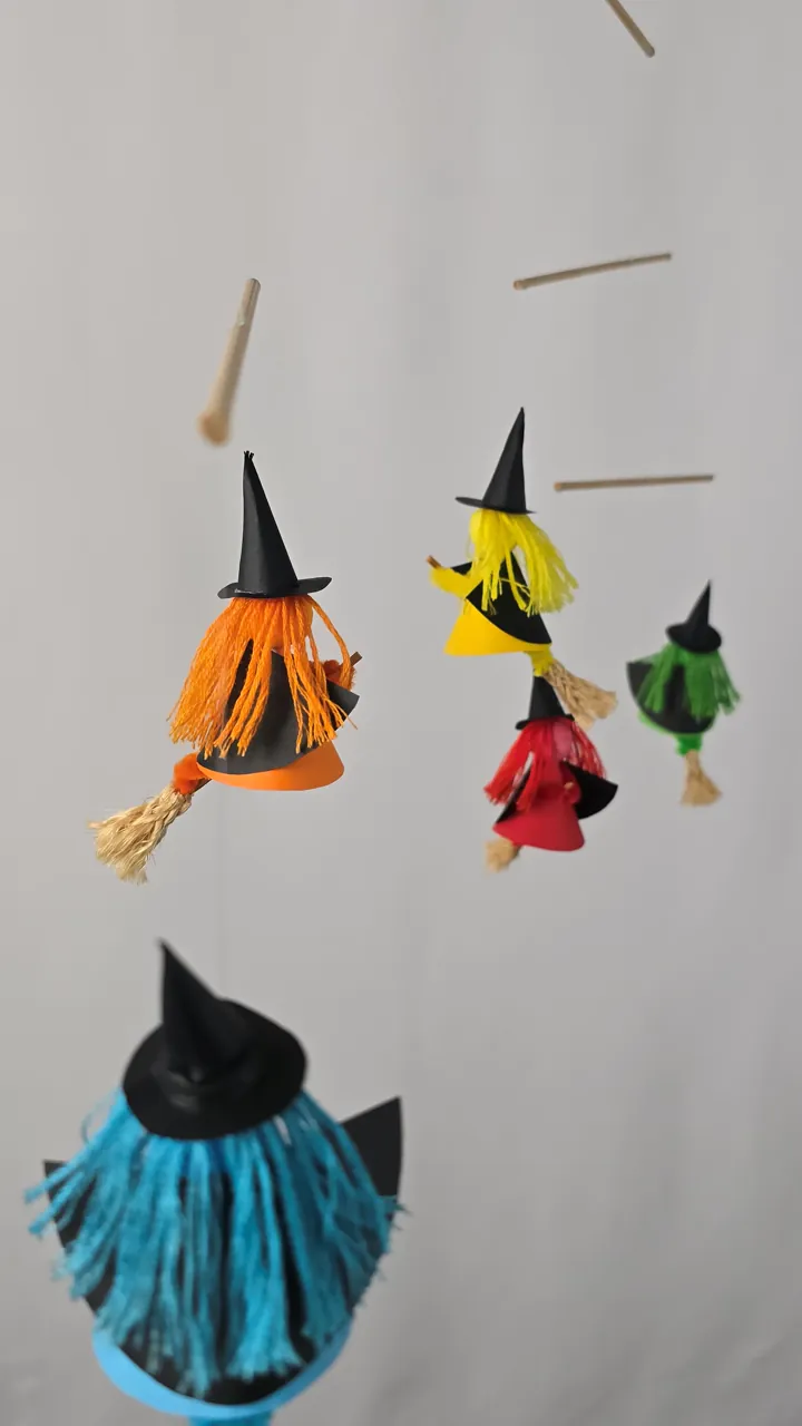 Mobile de gentilles sorcières - main de Clotilde tenant une sorcière colorée